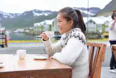 女人喝咖啡人行道上咖啡馆冰岛