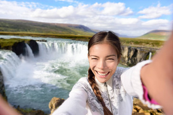 <strong>旅游</strong>采取视频自拍旅行戈达福斯瀑布冰岛快乐年轻的女人游客享受冰岛自然景观参观著名的<strong>旅游目的地</strong>吸引力冰岛