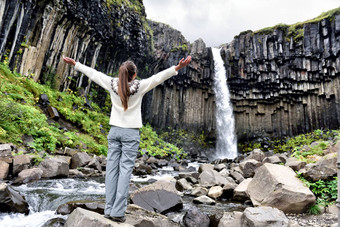 冰岛女人享受雄伟的黑色瀑布瀑布女参观著名的旅游吸引力冰岛壮观的自然具有里程碑意义的假期斯卡夫塔山冰岛自然景观
