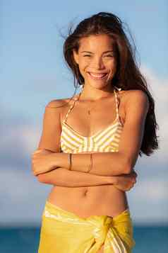美丽的亚洲年轻的女人穿黄色的比基尼微笑坦率地快乐夏天旅行海滩假期健康的微笑肖像