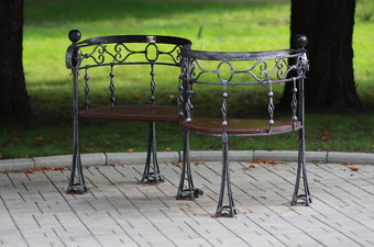 金属伪造的板凳上夏天公园
