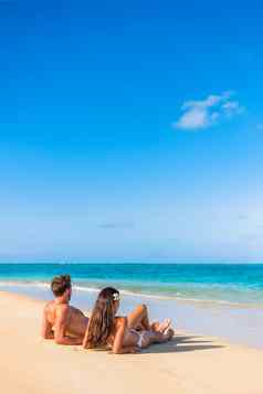 海滩假期夫妇晒黑热带太阳享受夏天假期旅行周围世界年轻的人说谎天堂垂直背景复制空间天空