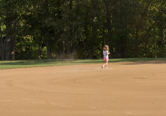 小女孩踢灰尘顺利斜棒球内野