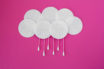 前视图粉红色的棉花味蕾白色头白色轮棉花磁盘铺设云雨滴粉红色的背景