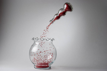红色的珠子下降悬浮玻璃花瓶