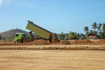 绿色转储卡车转储负载粘土建设网站路建设摩托曼达利卡赛车电路建设龙目岛印尼卡车运输行业运费货物运输