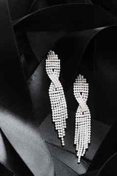 奢侈品钻石耳环黑色的丝绸丝带背景珠宝时尚品牌