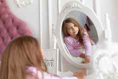 美丽的十几岁的女孩床边镜子
