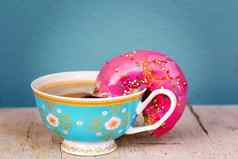 粉红色的上釉甜甜圈扣篮咖啡