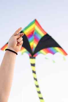 年轻的女人飞行风筝公共公园日落