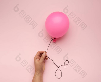 女手持有膨胀的粉红色的空气气球粉红色的引入
