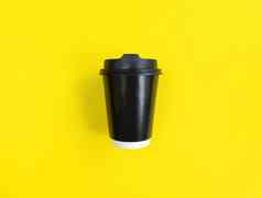 黑色的纸咖啡杯黄色的背景平躺风格最小的概念股票照片