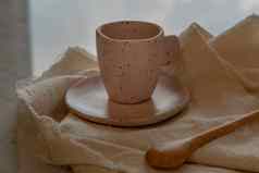 粉红色的陶瓷杯子手工制作的木勺子