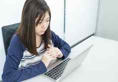 年轻的女学生坐着生活房间学习在线