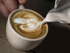 手咖啡师使拿铁咖啡馆杯咖啡美丽的拿铁艺术白色杯