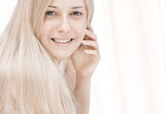 美脸特写镜头年轻的女人金发女郎头发别致的化妆护肤品头发的护理品牌
