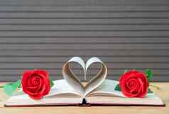 页面书弯曲的心形状红色的玫瑰