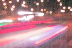 散焦头灯移动汽车多雨的湿玻璃