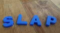 塑料彩色的字母使单词木地板上