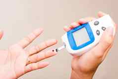 女人测量葡萄糖测试水平检查血手指