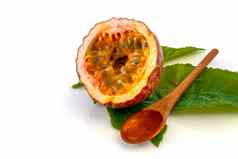 maracuja减少一半小玻璃容器皮水果木勺子叶白色背景激情水果黄色的水果汁种子