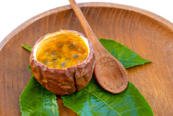 maracuja减少一半小玻璃容器皮水果木勺子叶板白色背景<strong>激情</strong>水果黄色的水果汁种子