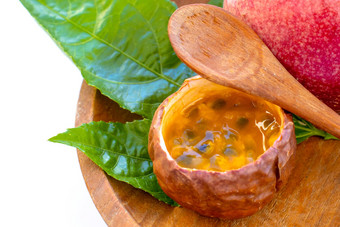 maracuja减少一半小玻璃容器皮水果木勺子叶板白色背景<strong>激情</strong>水果黄色的水果汁种子