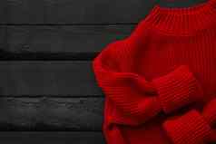 红色的针织毛衣木背景前视图