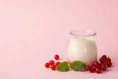 玻璃Jar酸奶油酸奶蔓越莓粉红色的背景