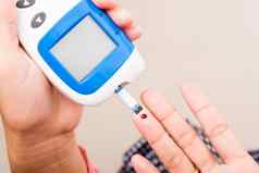 女人测量葡萄糖测试水平检查血手指