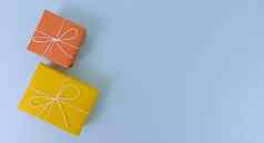 黄色的橙色礼物盒子蓝色的背景简单的平躺复制空间