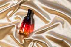 香水瓶黄金折叠丝绸织物背景