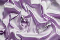 香水瓶脸血清淡紫色丝绸折叠织物背景