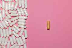 前视图白色药片一边单棕色（的）药丸一边粉红色的背景复制空间医疗保健医疗制药概念