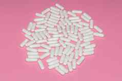 高角拍摄白色药片粉红色的背景医疗保健医疗制药概念