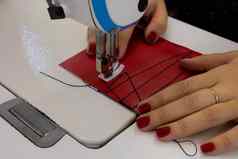 裁缝缝纫衣服红色的布缝纫机钢针电影印刷机脚特写镜头