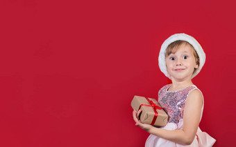 可爱的可爱的微笑女孩持有圣诞节礼物孤立的红色的