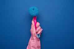 手粉红色的橡胶手套清洁房子持有塑料
