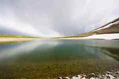 高山山湖景观白天色彩斑斓的景观雪云