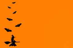 轮廓群蝙蝠女巫飞行扫帚使黑色的纸橙色背景万圣节问候模板复制空间平躺设计现成的模板