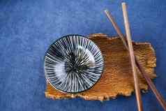 空亚洲餐具碗馅饼筷子蓝色的背景
