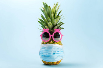 科维德旅行概念<strong>菠萝</strong>太阳镜医疗面具蓝色的背景<strong>菠萝粉红色</strong>的太阳镜脸面具正常的旅行