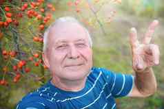 积极的退休祖父使自拍照片智能手机公园上了年纪的男人。走自然