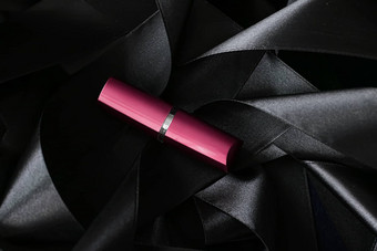 粉红色的口红黑色的丝绸背景奢侈品化妆漂亮的东西或人