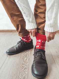 年轻的男人。拉腿中国裤子显示明亮的红色的袜子驯鹿斯堪的那维亚模式冬天假期精神休闲装一年圣诞节庆祝活动