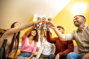 底视图多少数民族年轻的朋友集团首页坐着沙发敬酒白色酒眼镜多民族的快乐人有趣的喝香槟事件庆祝活动