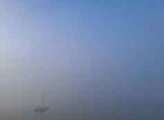 冷有雾的海洋小白色游艇浮动海