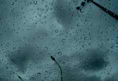 雨滴透明的玻璃模糊黑暗狂风暴雨的天空