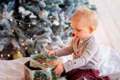 快乐婴儿男孩开放现在盒子圣诞节树