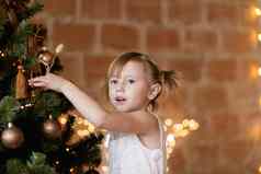 可爱的女孩别致的衣服挂起圣诞节玩具树